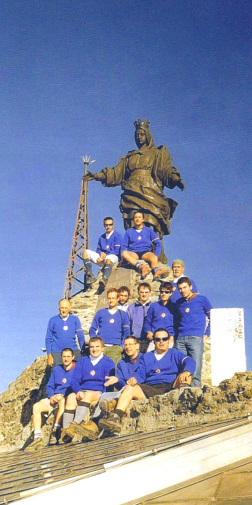 Il gruppo di cantori del Coro Alpi Cozie ai piedi del monumento alla Madonna in vetta, nel 2005, foto  aut./CAC